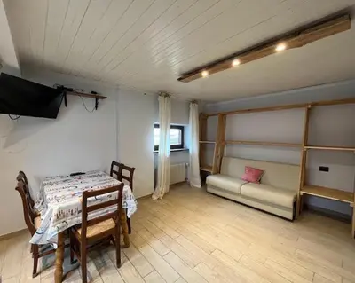 a room with a table and chairs and a tv at Casa Karin in Canazei
