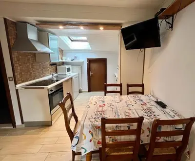 a dining room with a table and chairs and a kitchen at Casa Karin in Canazei