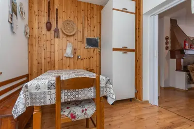 a table in a room with a wooden wall at Villa Elisena in Falcade