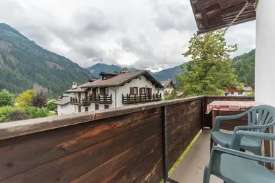 a balcony with a wooden fence and two chairs at Villa Elisena in Falcade