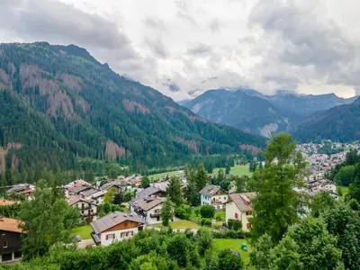 a village in a valley with mountains in the background at Villa Elisena in Falcade