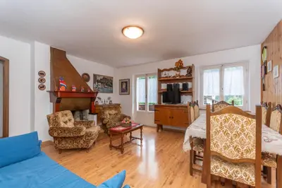 a living room with a blue couch and a table at Villa Elisena in Falcade