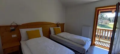 two beds in a room with a window at Locanda Val Canali in Siror
