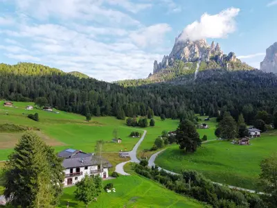a valley in the mountains with a house and a road at Locanda Val Canali in Siror