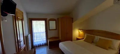 a bedroom with a large bed and a window at Locanda Val Canali in Siror
