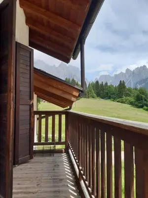 a balcony of a cabin with a view of the mountains at Locanda Val Canali in Siror