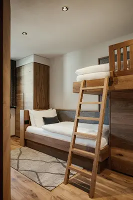 a bedroom with two bunk beds and a ladder at Apartments Villa Sofia in Santa Cristina in Val Gardena