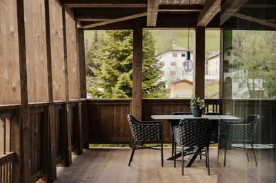 a patio with a table and chairs on a wooden deck at Apartments Villa Sofia in Santa Cristina in Val Gardena