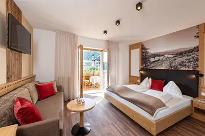 a hotel room with a bed and a couch at Hotel Schallerhof in Tesimo