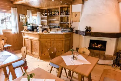 a restaurant with a fireplace and tables and chairs at Hotel Schallerhof in Tesimo