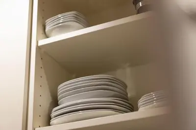 a stack of white dishes sitting on a shelf at App Mittermairhof in Riscone