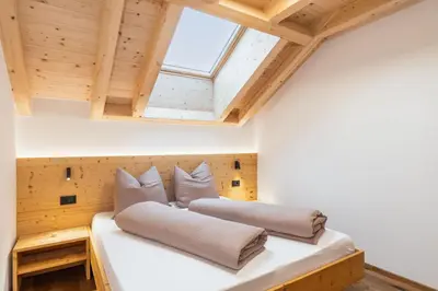 two pillows on a bed in a room with a skylight at App Mittermairhof in Riscone
