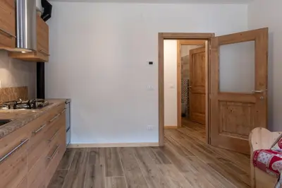 a kitchen with wooden floors and a wooden door at SUITE203 in Noàc