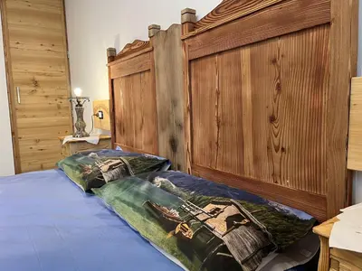 a bedroom with a large bed with a wooden headboard at SUITE203 in Noàc