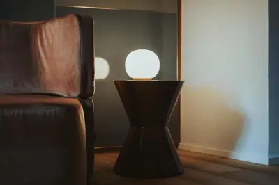 a lamp sitting next to a chair in a room at Arthotel Lasserhaus in Bressanone