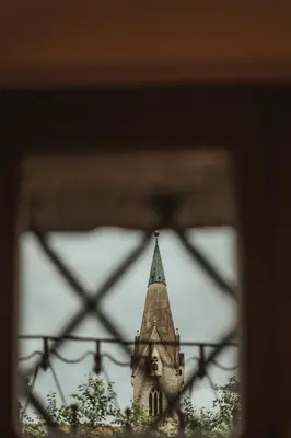 a church steeple is seen through a window at Arthotel Lasserhaus in Bressanone