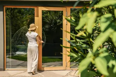 a woman standing in front of a glass door at Alpwellhotel Burggräfler in Tesimo