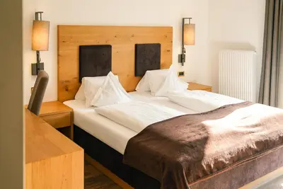 a bedroom with a large bed with white sheets at Alpwellhotel Burggräfler in Tesimo