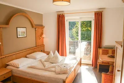 a bedroom with a bed with white pillows and a window at Alpwellhotel Burggräfler in Tesimo