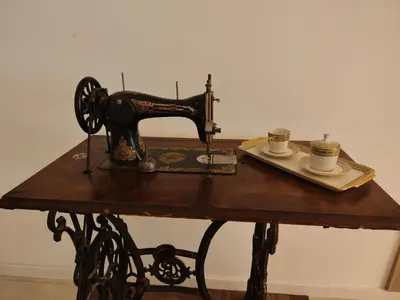 a sewing machine and two cups on a table at Jolli Mountain in Bolzano