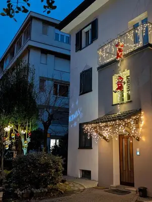 a building with christmas lights on the side of it at Jolli Mountain in Bolzano