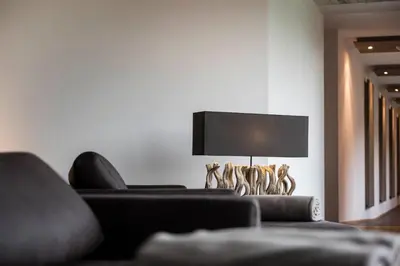 a living room with a couch and a lamp at Hotel Hofbrunn in Rifiano