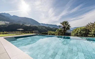 a swimming pool with a view of mountains at Hotel Hofbrunn in Rifiano