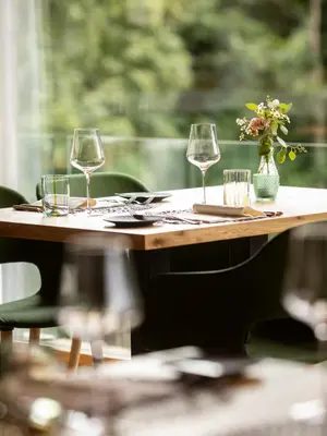 a table with wine glasses and a vase of flowers at Ladurner in Lagundo