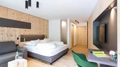 a bedroom with a bed and a couch and a table at Ladurner in Lagundo