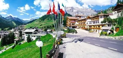 a view of a street in a village with flags at Dolomites Base Camp Hotel Olympia in Arabba