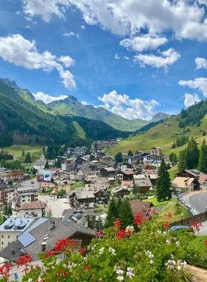a small town in the mountains with flowers at Dolomites Base Camp Hotel Olympia in Arabba