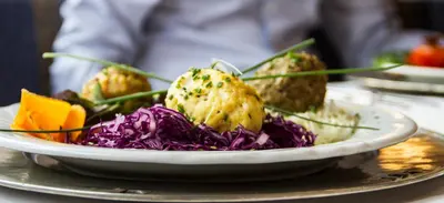 a plate of food with purple cabbage and carrots at Dolomites Base Camp Hotel Olympia in Arabba