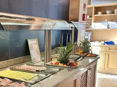 a kitchen with a counter with food on it at Dolomites Base Camp Hotel Olympia in Arabba