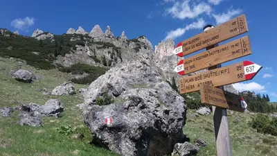 a sign with many signs on a mountain at Dolomites Base Camp Hotel Olympia in Arabba