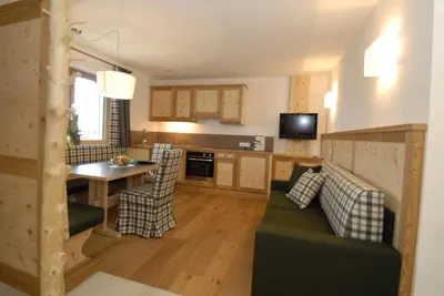 a kitchen and living room with a couch and a table at Mühlerhof in Funes