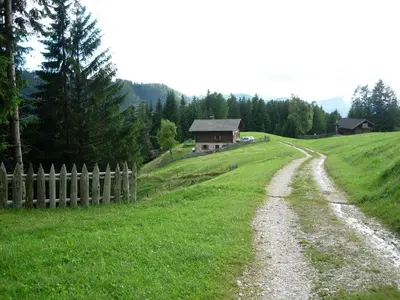 a dirt road in a field next to a house at Berghütte Plafötschalm in Tires