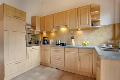 a large kitchen with wooden cabinets and appliances at Angerle Hof in Nova Levante