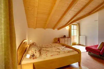 a bedroom with a bed with a wooden ceiling at Angerle Hof in Nova Levante