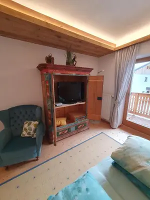 a living room with a tv and a couch and a chair at Apartement Schuster Lake Prags Braies in Braies
