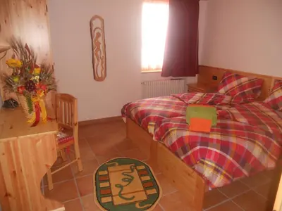 a bedroom with a bed and a wooden wall at Agritur Melango in Fondo
