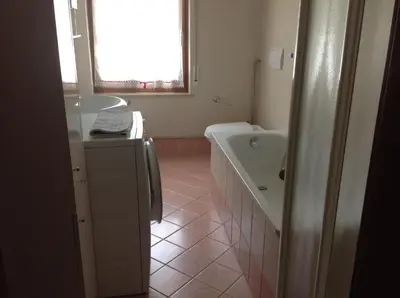 a bathroom with a tub and a sink and a bath tub at Casa Berlanda in Fiera di Primiero