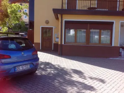 a small blue car parked in front of a house at Casa Berlanda in Fiera di Primiero