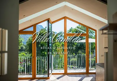 a glass door to a restaurant with a sign at Villa Camilde - elegance and relax in Merano in Merano