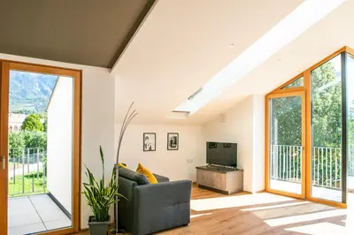 a living room with a couch and a television at Villa Camilde - elegance and relax in Merano in Merano