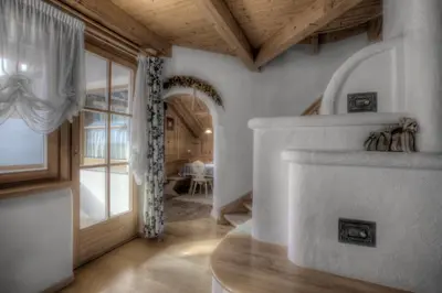 a living room with a fireplace and a wooden ceiling at Alexander Mountain-Lodge in San Vigilio Di Marebbe