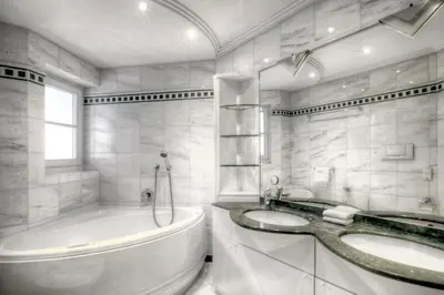 a white bathroom with two sinks and a tub at Alexander Mountain-Lodge in San Vigilio Di Marebbe