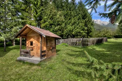 a small wooden out house in a yard at Alexander Mountain-Lodge in San Vigilio Di Marebbe