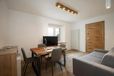 a living room with a table and a couch at SnowLake Suite & Apartment in Alleghe