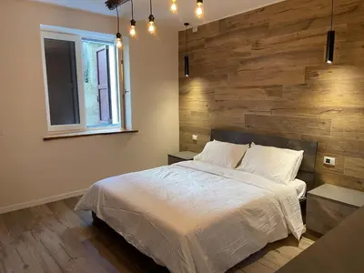 a bedroom with a large bed with a wooden wall at SnowLake Suite & Apartment in Alleghe