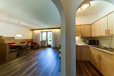 an open kitchen and living room with a dining room at Residence Krone in Schenna
